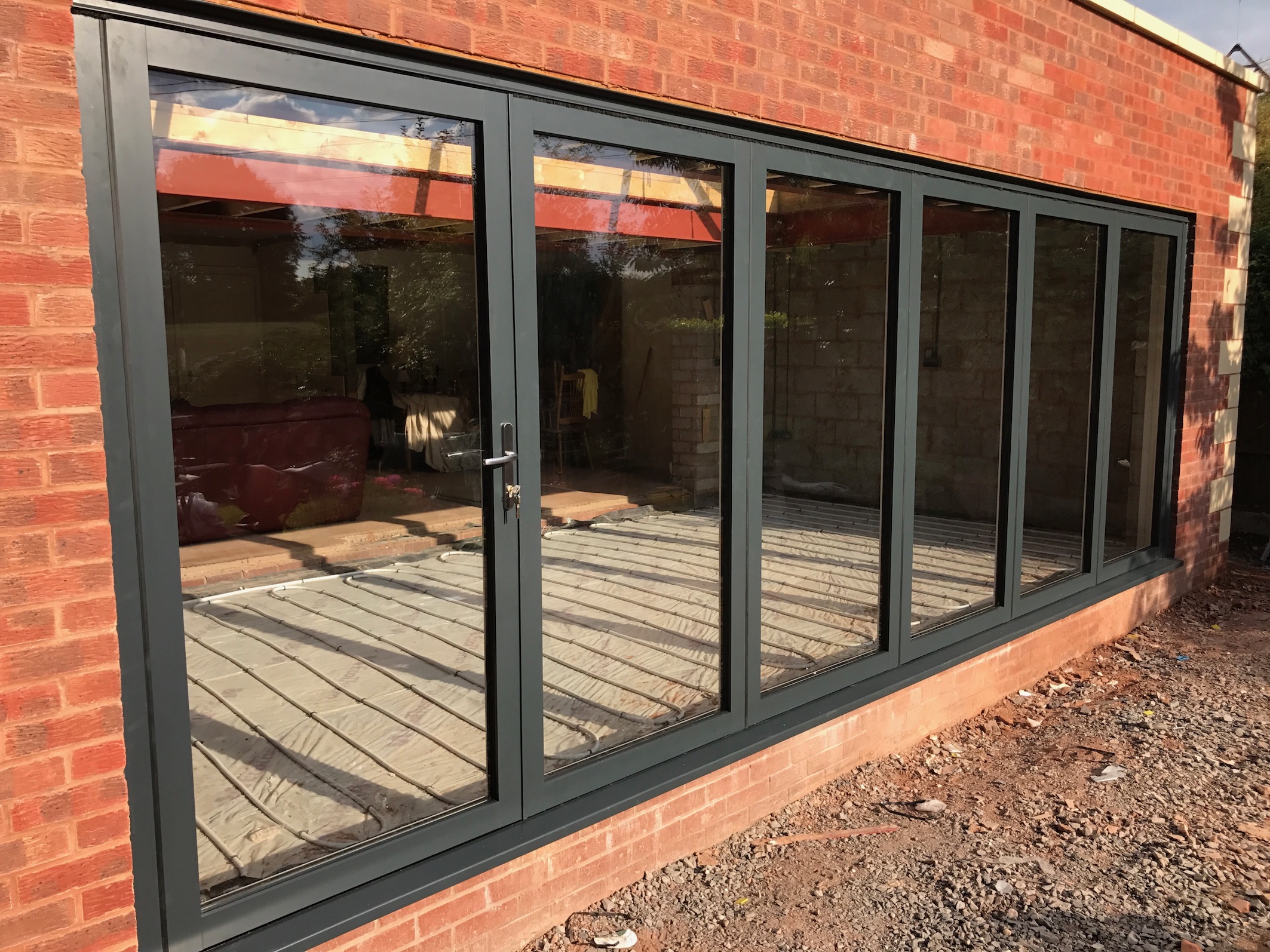 swing and slide door in black frame against orange brick wall